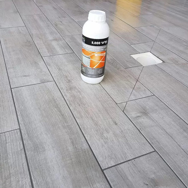 קלינר 5000 פלוס בקבוק קטן על רצפה נקייה מחומרי בנייה